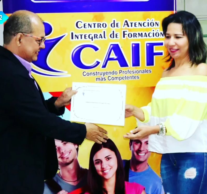 Entrega de un certificado frente al pendón de CAIF